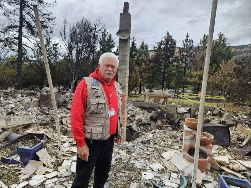 A Red Cross volunteer inspects damage after a wildfire