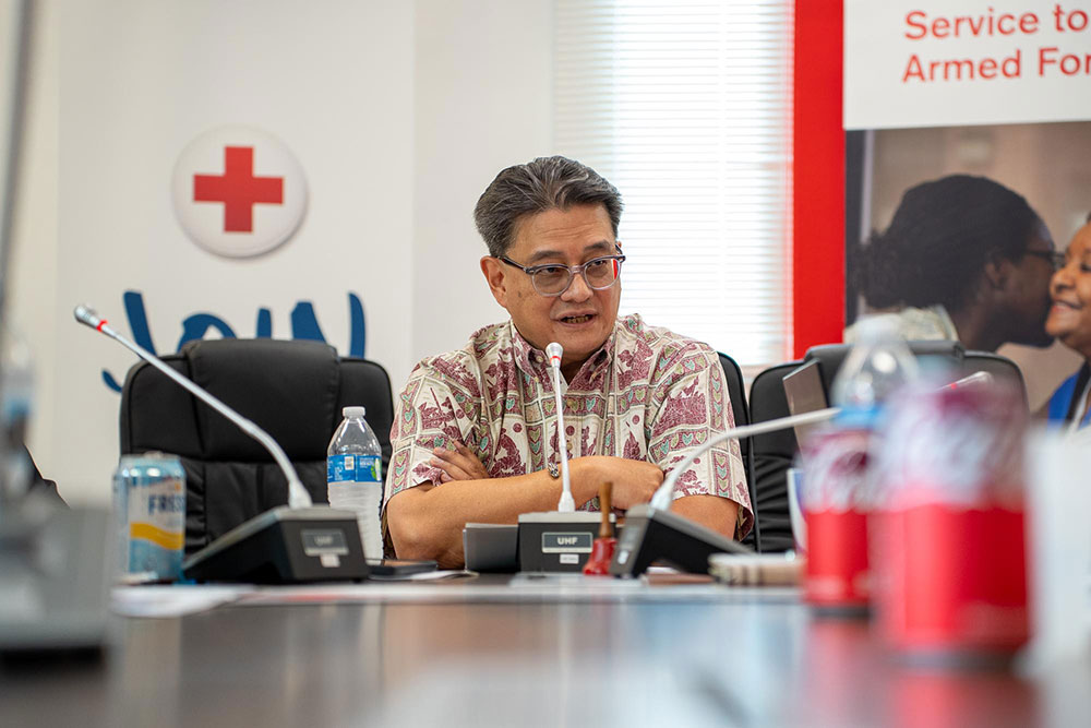 Edward G. Untalan, sitting at a table with a mic, speaks during a press conference.