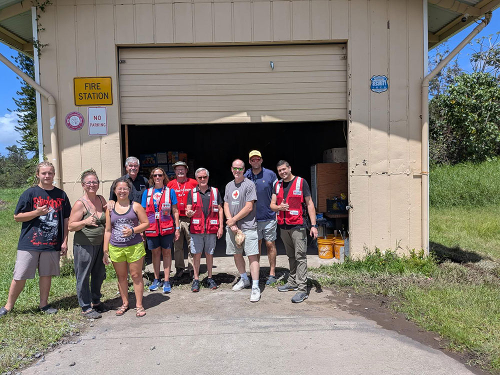 a group of Red Cross volunteers in front of a fire station.