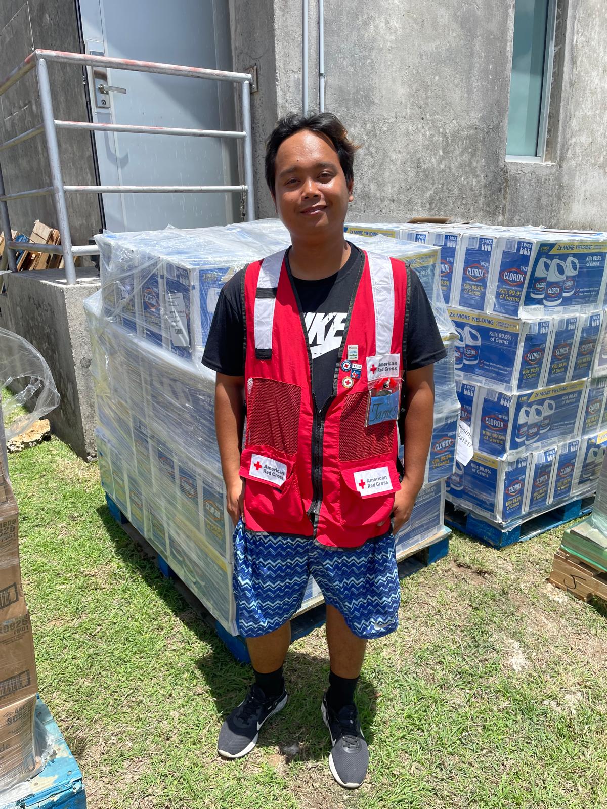 volunteer james standing in front of disaster supply materials