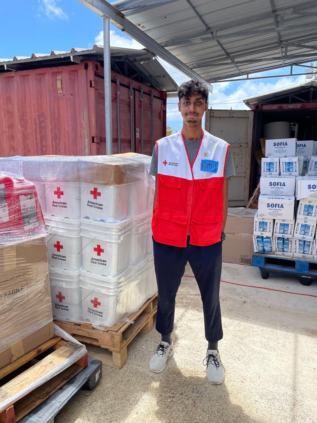 volunteer robait standing next to supply of red cross materials
