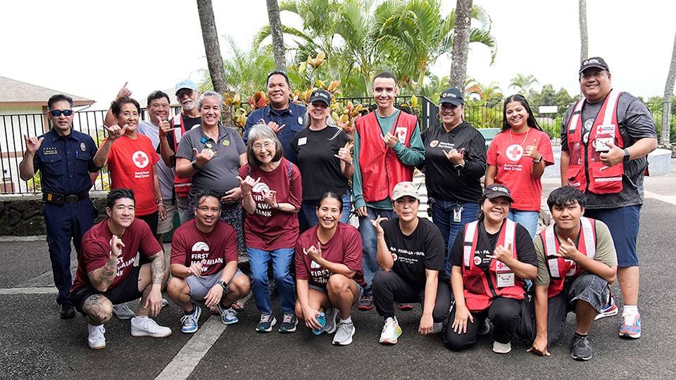 Group pic of Red Cross volunteers and firefighters all giving the shaka sign.