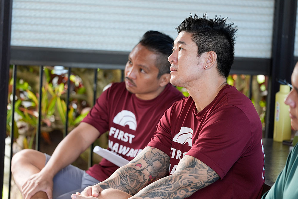 Red Cross volunteers sitting and listening in a room.