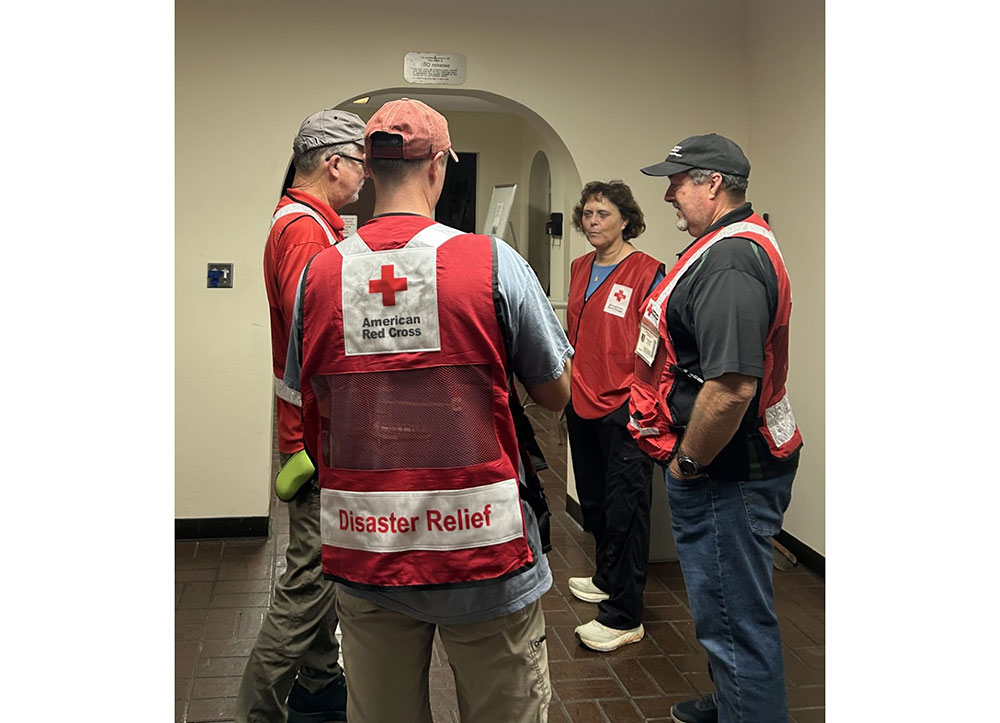 Four Red Cross volunteers talking to each other in the Paki Hale shelter.