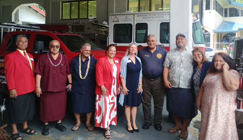 Red Cross staff members and American Samoa Board members next to fire engine and fire truck.