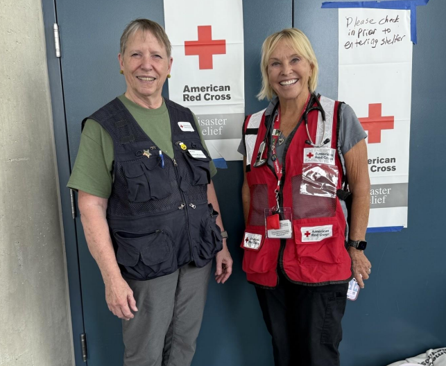 two red crossers standing in front of red cross signage