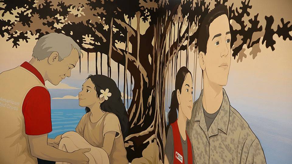 Mural painting on the inside wall of a Red Cross building of a Red Cross volunteer helping another person and a Red Cross volunteer with a soldier in camo.