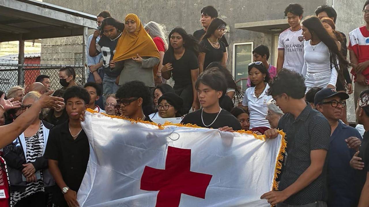 group of people holding red cross flag in saipan