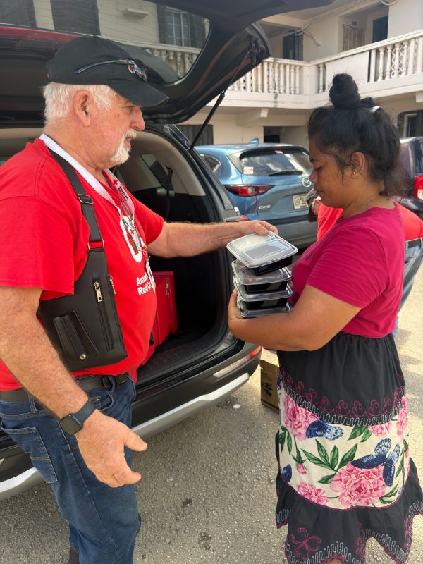volunteer handing out food to woman
