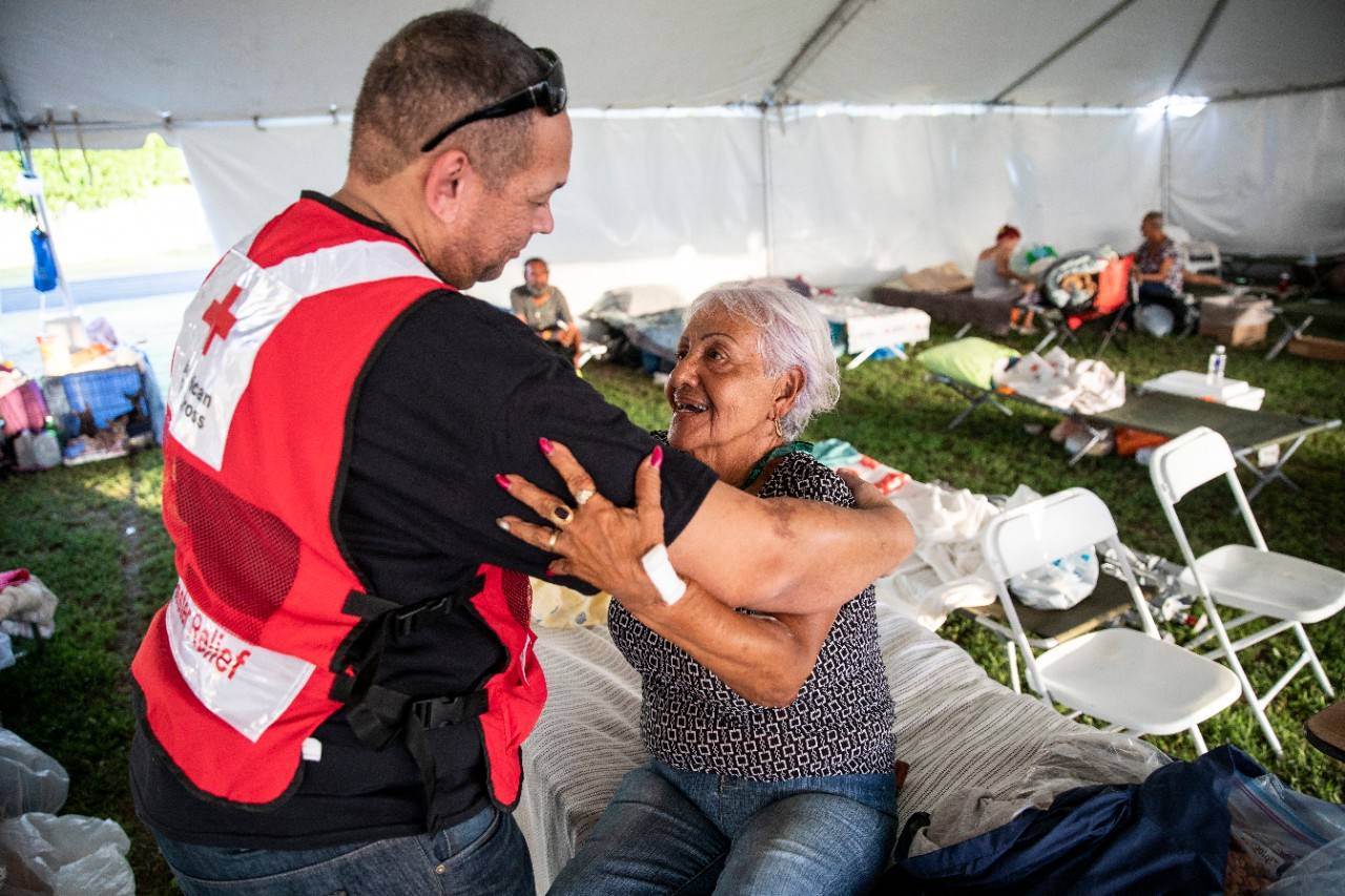 January 15, 2020. Guánica, Puerto Rico.
Pista Complejo Deportivo Edilberto Cruz - Shelter resident Ana Lidia speaks with American Red Cross member AJ Suero after receiving medical care at a temporary shelter due to dehydration.
Photo by Scott Dalton/American Red Cross