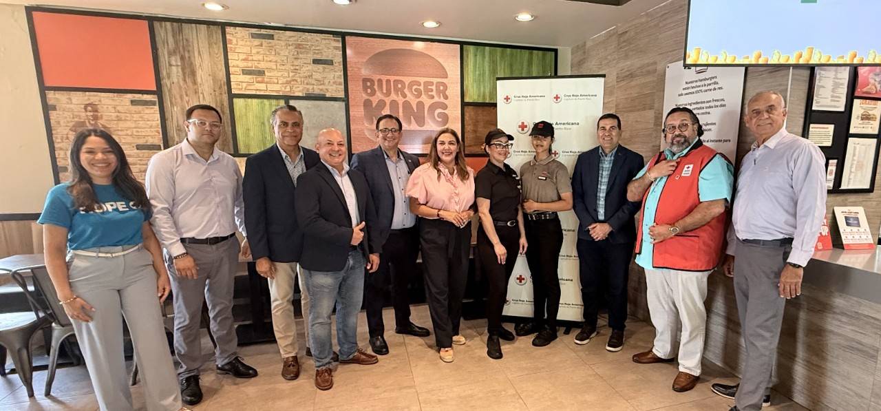 Gerenciales de Cruz Roja y Burger King Puerto Rico de pie posan dentro del Burger King.