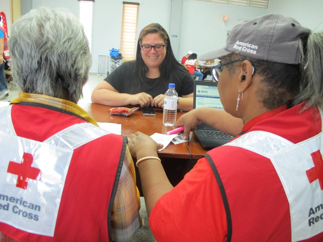 Voluntarias Gloria Cintrón y Mary Estes junto a la residente Rebeca Díaz, cuyo hogar es inhabitable.