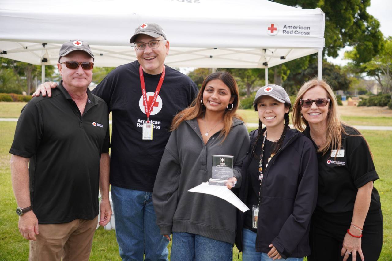 Ananya holding an award alongside fellow Red Crossers