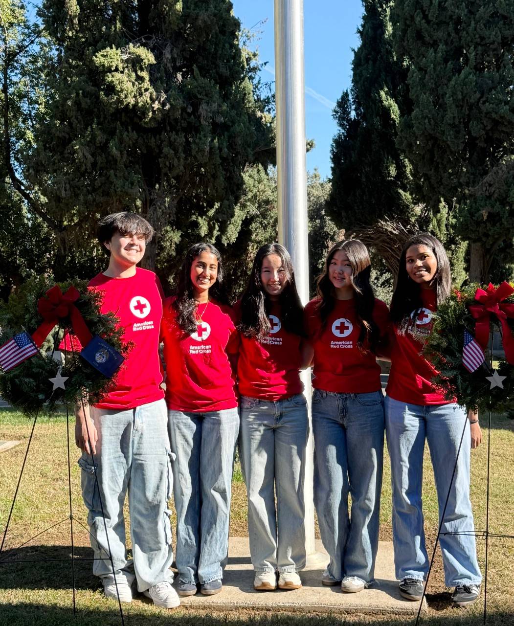 A group of smiling Red Cross youth volunteers in Red Cross t-shirts 