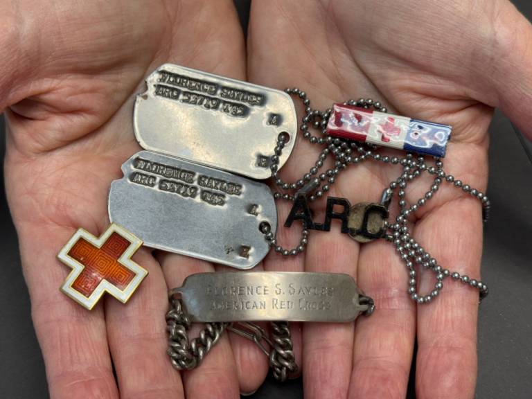 Open hands holding old Red Cross memorabilia 