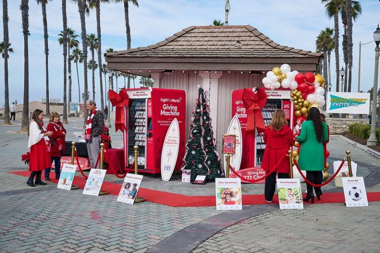 Red Cross volunteers standing by Light the World Giving Machines in Huntington Beach.