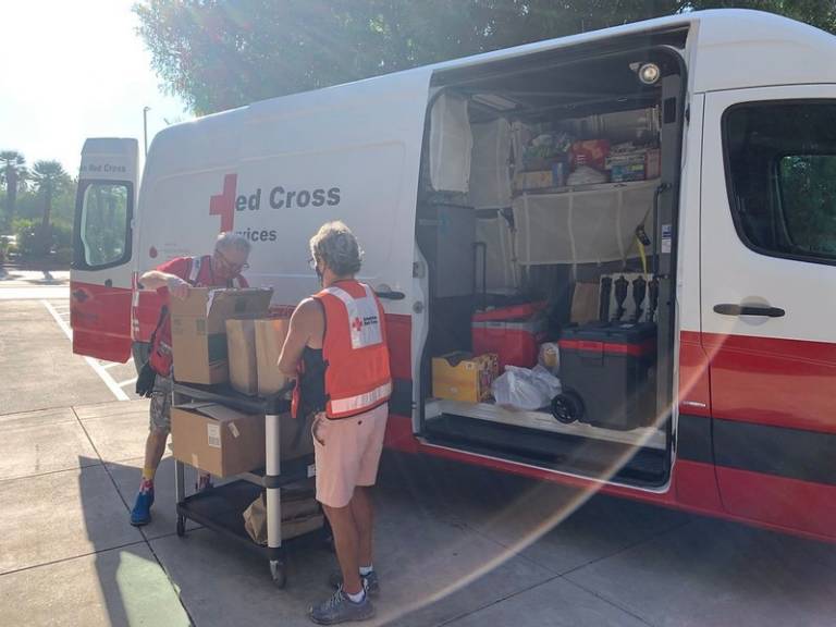 Red Cross volunteers unload boxes of meals