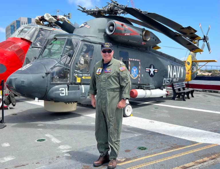 Individual standing in front of helicopter.