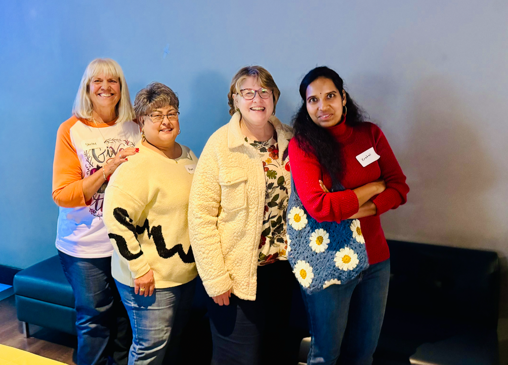 Four women posed smiling
