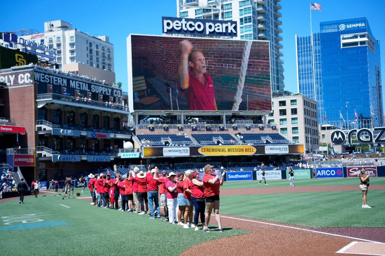 Red Cross volunteer on the Petco Park field and Rick ringing the mission bell on the jumbotron