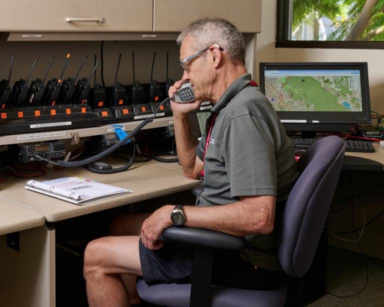 Red Cross volunteer talks into radio.