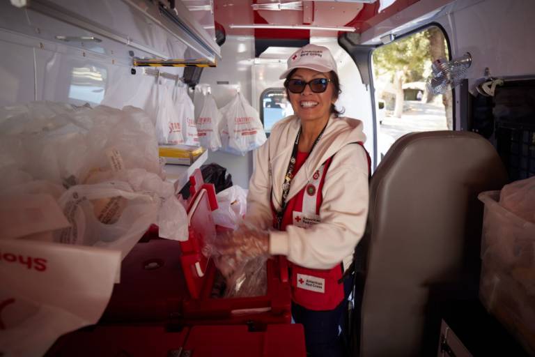 American Red Cross volunteer inside of a Red Cross Emergency Response Vehicle preparing meals to be distributed to local residents affected by a wildfire.