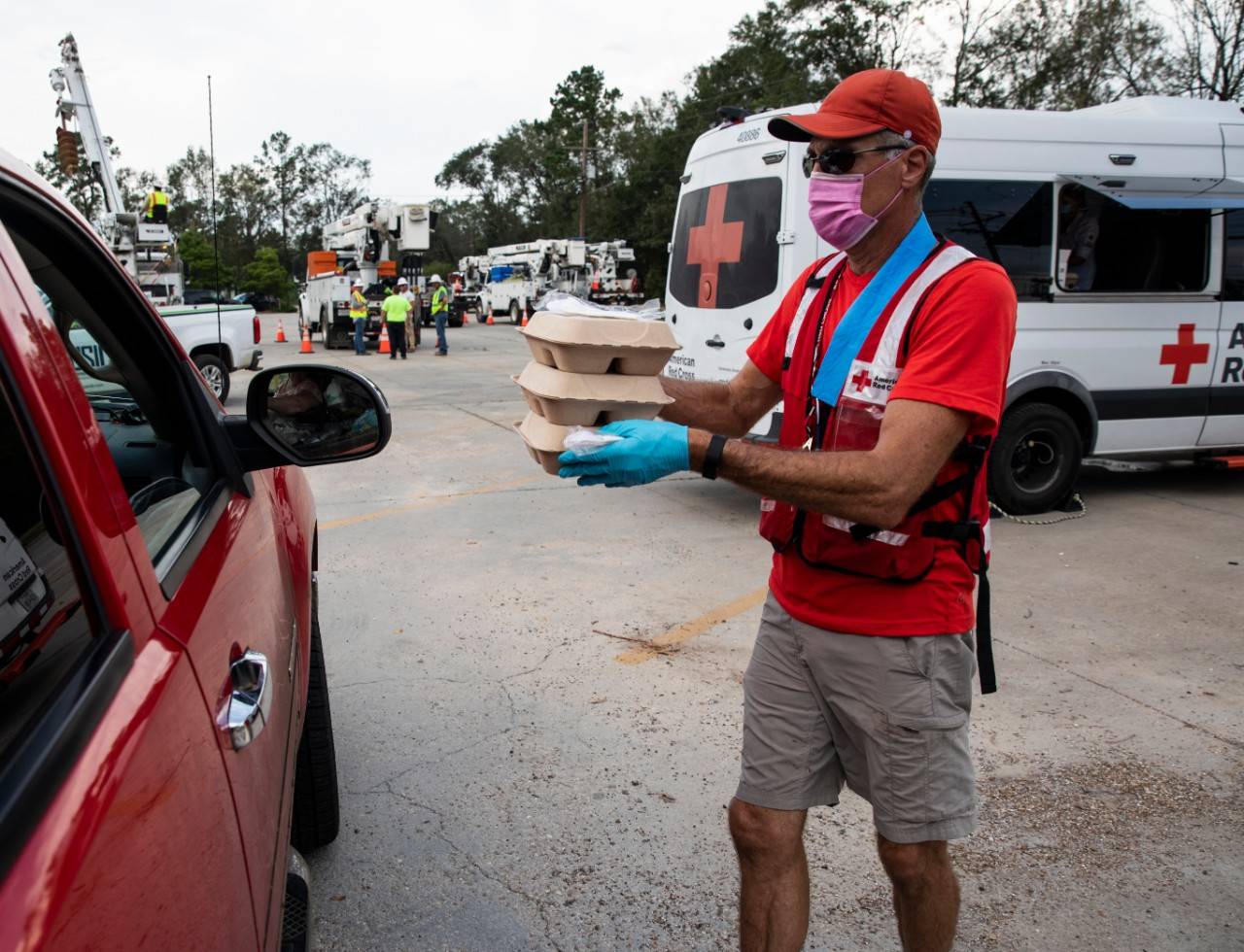 September 7, 2021. Ponchatoula, Louisiana. American Red Cross volunteer Mark Howell runs hot meals to residents in their vehicles at a food distribution site in Ponchatoula, Louisiana. Red beans and rice are placed in new Monogram® biodegradable containers.  

Monogram® products are designed to have minimal environmental impact in both manufacturing and waste disposal.  They are heat and cold resistant, keeping food icy-cold or steaming hot. The Monogram® clam shells containers seen here are created using high-quality molded-fiber pulp derived from natural agricultural byproducts. Lightweight, strong and durable, Monogram® products are a welcome partner in American Red Cross mission to alleviate human suffering through disaster relief efforts. Photo by Scott Dalton/American Red Cross

