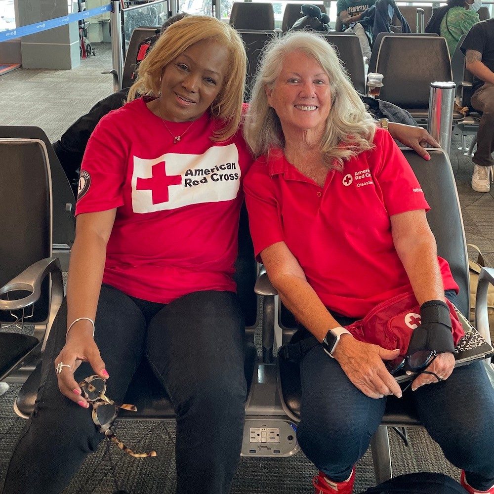 Two volunteers in red cross tee-shirts at airport deploying to support hurricane idalia