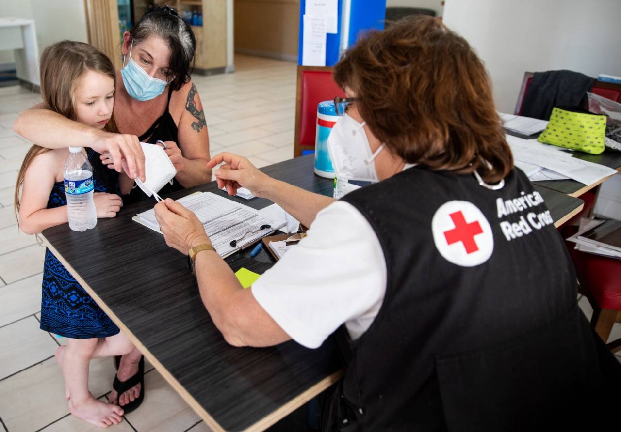 April 24, 2020. Livingston, Texas.
Clarruth Seaton of The American Red Cross draws a smiley face on a mask she just gave to 7 yr old Ariya. Ariya and her family are staying at the hotel where Red Cross is providing emergency lodging for people whose homes were damaged by the tornado earlier this week. The shelter is just a few miles from Onalaska, TX, the community that was hit by the powerful tornado that damaged hundreds of homes on April 22, 2020.
Photo by Scott Dalton/American Red Cross