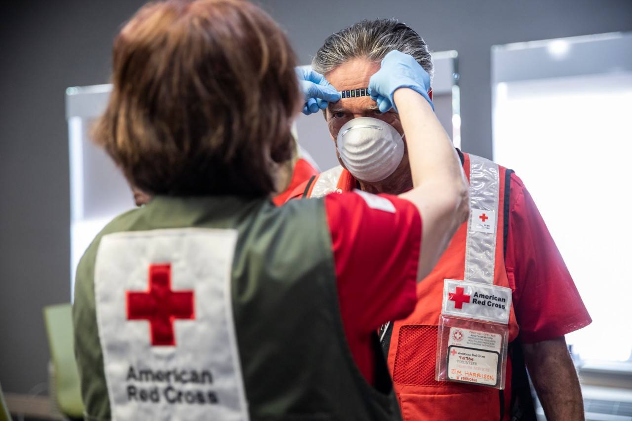 April 26, 2020. Livingston, Texas.
Cheryl Thomas, a nurse for the American Red Cross, checks the temperature of Red Cross volunteer Jim Harrison, as part of Covid-19 screening protocol at a hotel in Livingston, TX on Sunday, April 26, 2020. The hotel is one of several where the Red Cross is providing emergency lodging for families whose homes were damaged or destroyed in Onalaska, TX, the community that was hit by a powerful tornado on April 22, 2020.
Photo by Scott Dalton/American Red Cross