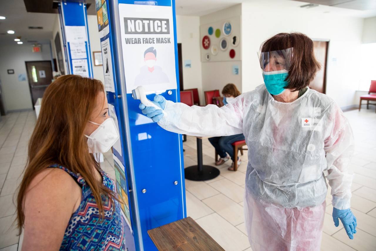 April 26, 2020. Livingston, Texas.
Cheryl Thomas, a nurse for the American Red Cross, checks the temperature of Cheryl Frautschi, as part of Covid-19 screening protocol at a hotel where the Red Cross is providing emergency lodging for families whose homes were damaged or destroyed by the powerful tornado that hit Onalaska, TX on April 22, 2020.
Photo by Scott Dalton/American Red Cross