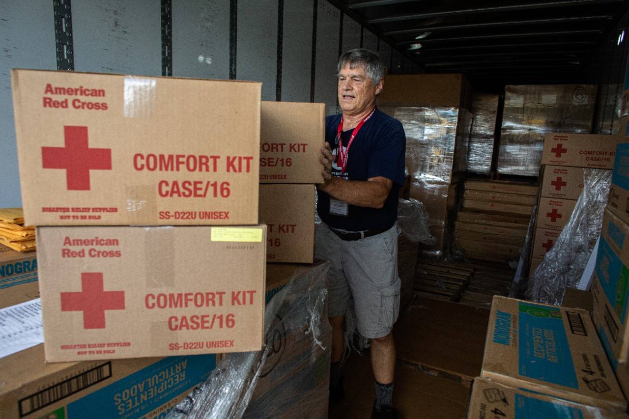 September 26, 2022. Orlando, Florida
Red Cross Fulfillment Team volunteers working ahead of Hurricane Ian, unload tractor trailers of supplies at the ESPN Center in Orlando, Fl. The goods will be heading to evacuation shelters all across Central Florida. The supplies include cots, blankets, gloves, flashlights and clean-up kits. The Fulfillment Team is working towards the Red Cross goal of supplying every need of every shelter every day. Team member Paul Duclos, from Greenwood, ME, was inspired to volunteer during Hurricane Harvey. "I went online to donate," he recalled, "and I saw the volunteer button on the website and clicked it. The next day they called, day after that we trained and the following day we were working at a shelter in Houston. My wife and I stayed there for three weeks and we've never looked back. I think in all, we've done 12 deployments."
Photo by Marko Kokic/American Red Cross
