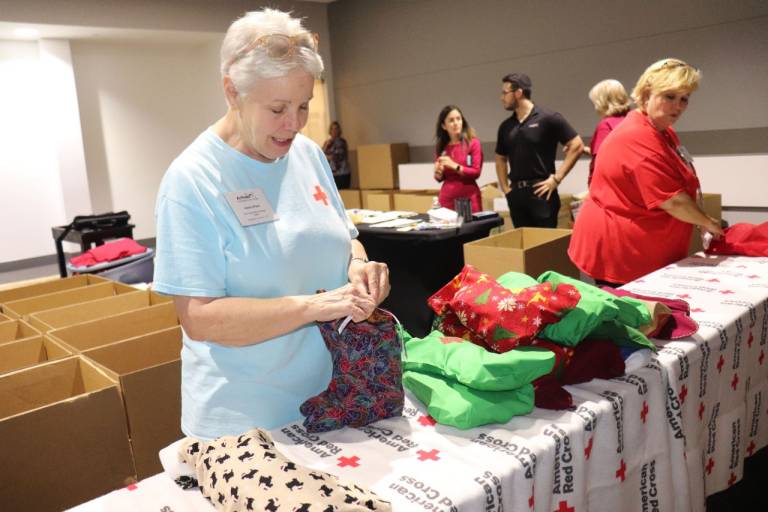 Red Cross volunteer ties up a stocking. 