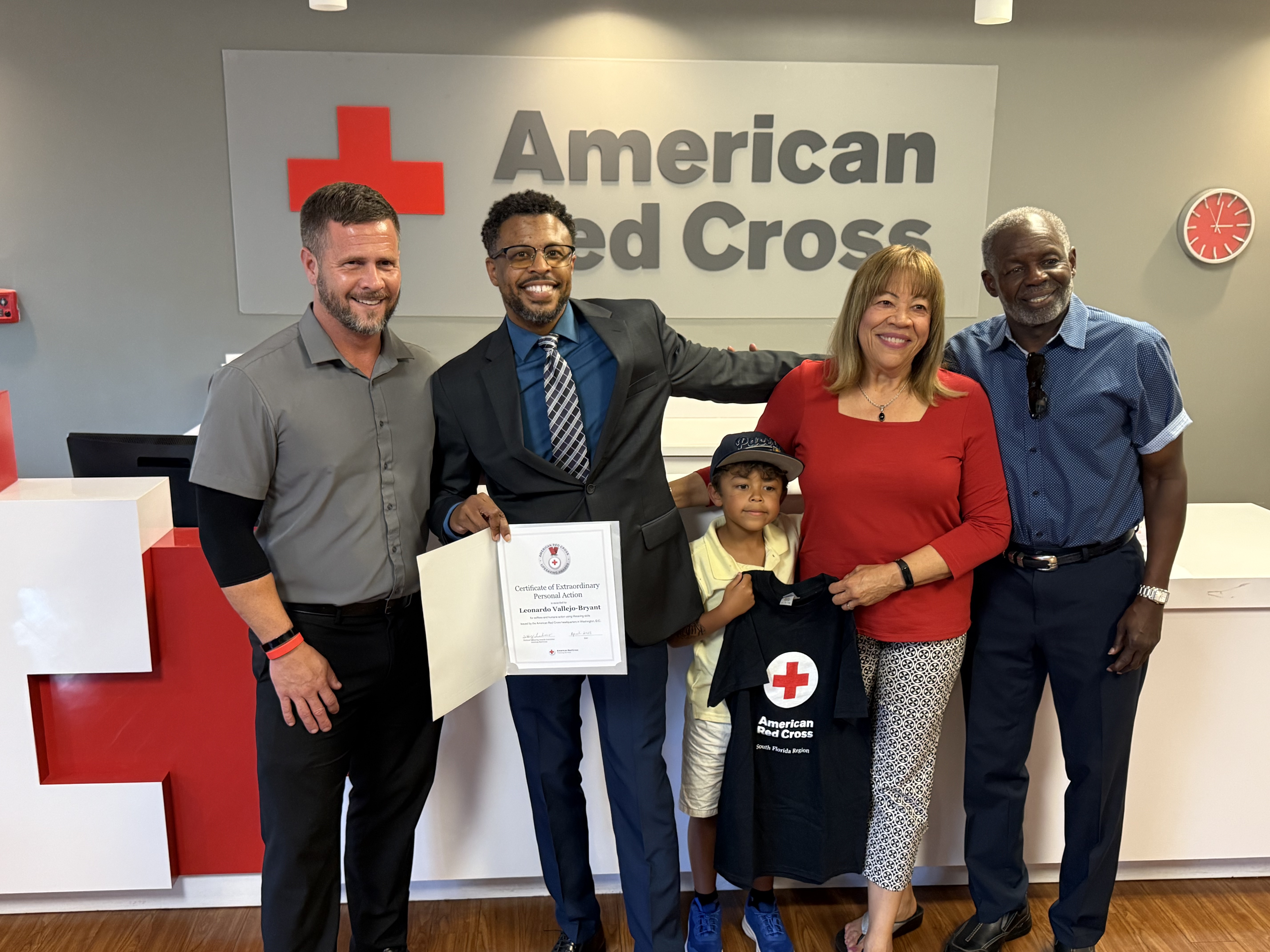 Leo Vallejo-Bryant receiving an award surrounded by family members.