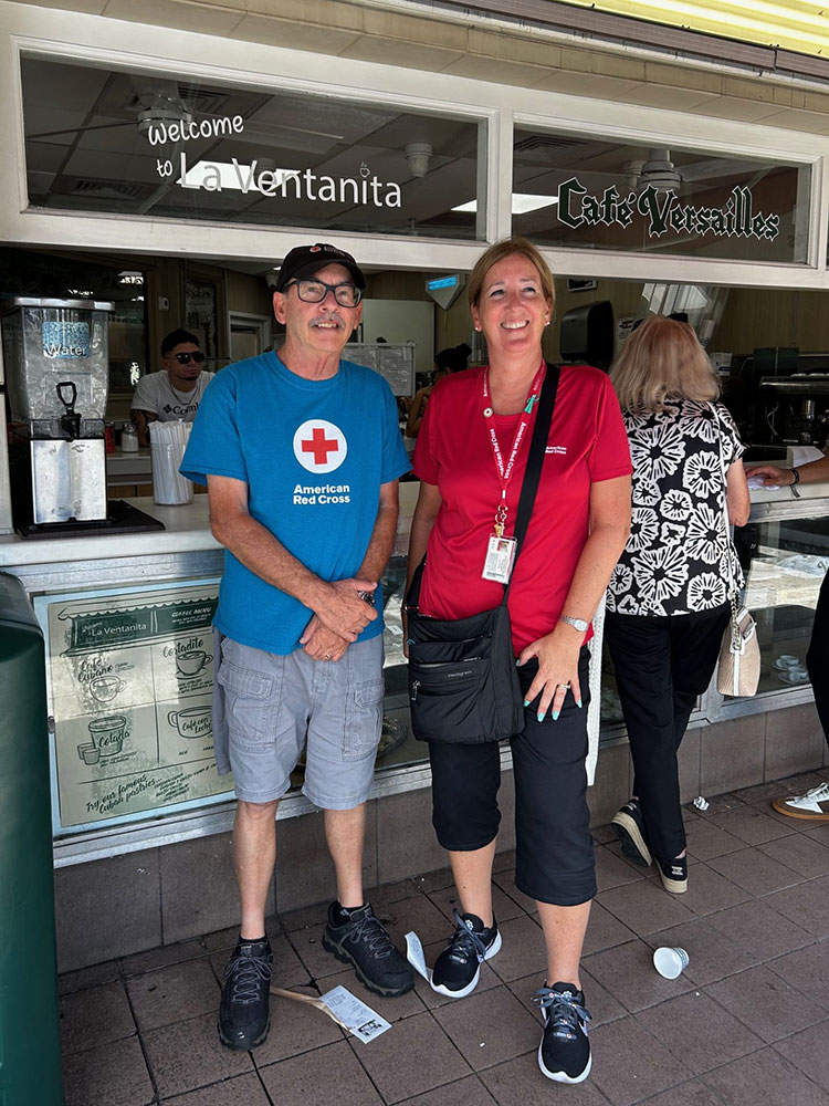 Red Cross volunteer, Michelle Bratton standing next to another volunteer outside a cafe.