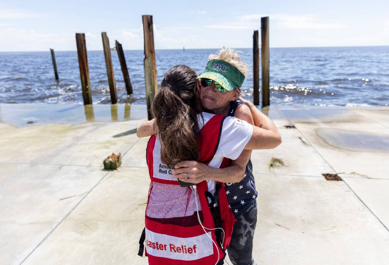 August 31, 2023. Horseshoe Beach, Florida.
Red Cross disaster responder, Dariana Molina, provides comfort to Horseshoe Beach, Florida, resident Shelley Thomas, on the location where her home once stood. The home, which had been in her family for generations, was destroyed by Hurricane Idalia s strong winds and storm surge.  It s been standing for 68 years and it s where all our memories were made,  said Shelly. As a result of the climate crisis, hurricanes are becoming more intense and more destructive with increased rainfall and higher storm surges.
Photo by Scott Dalton/American Red Cross