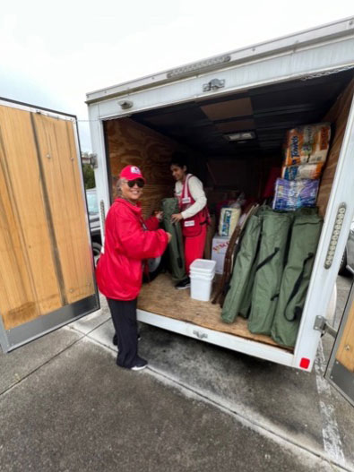 Red Cross volunteer, Veronica Block helping unload items from the back of a moving van.
