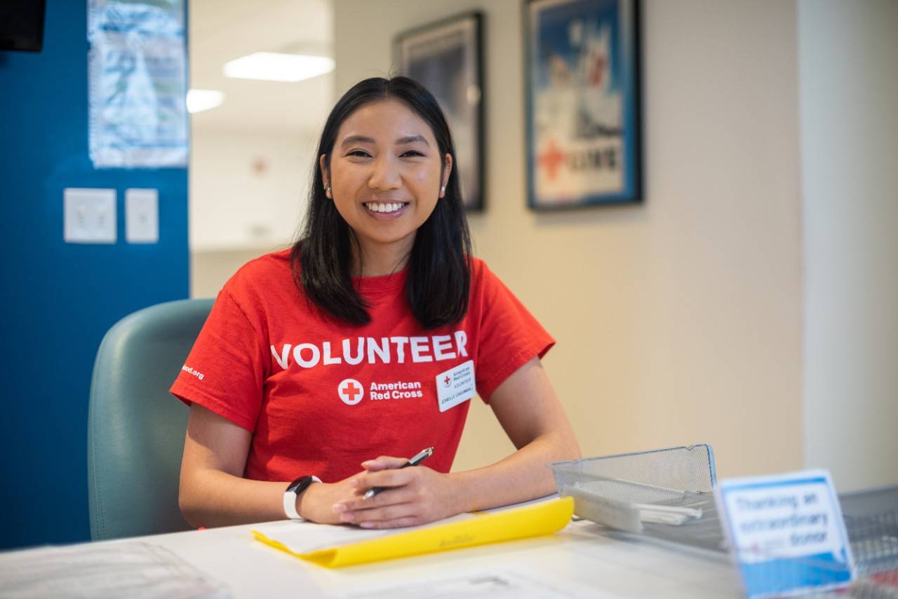 Volunteer smiling and posing from behind a desk