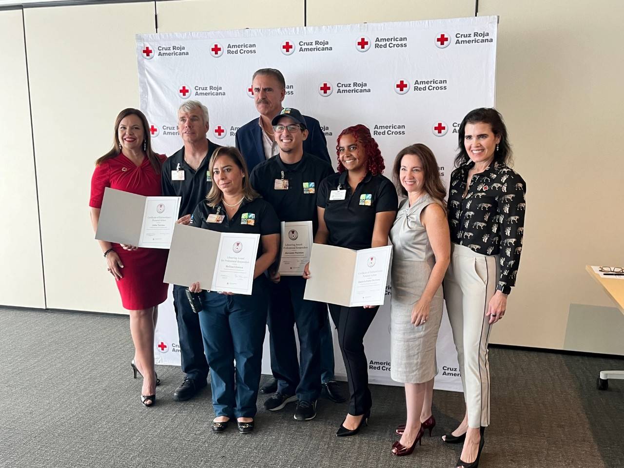 Zoo Miami staff members John Toreno, Melissa Llerena, Jiovanni Puentes and Daniela Perez Hererra holding their Red Cross Lifesaving Awards with Red Cross mambers next to them.