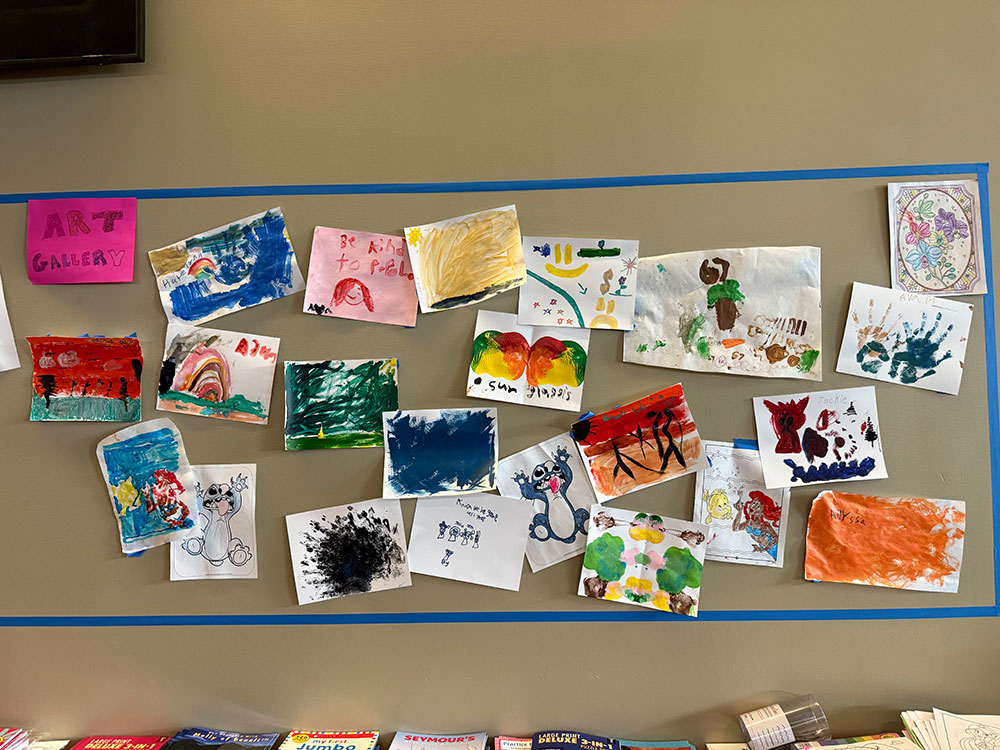 children's hand drawings hanging on a wall.