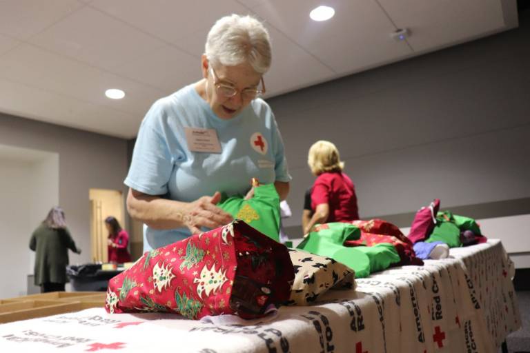 Red Cross volunteer prepares a holiday stocking