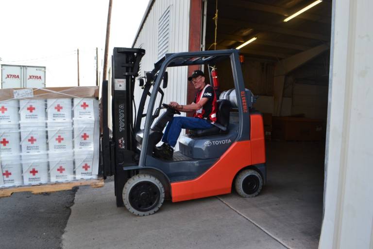 Phil Ward driving a forklift at a warehouse.
