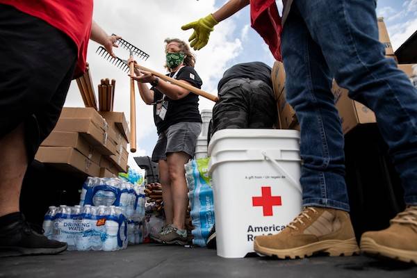 July 30, 2020. Mercedes, Texas.
American Red Cross volunteer Pam Simone helps unload items to be given to families in an area affected by Hurricane Hanna in Mercedes, TX on Thursday July 30, 2020. The Red Cross teamed up with the local fire department to drive through neighborhoods and hand out cleaning kits, rakes, shovels, water and tarps to those in need.
Photo by Scott Dalton/American Red Cross