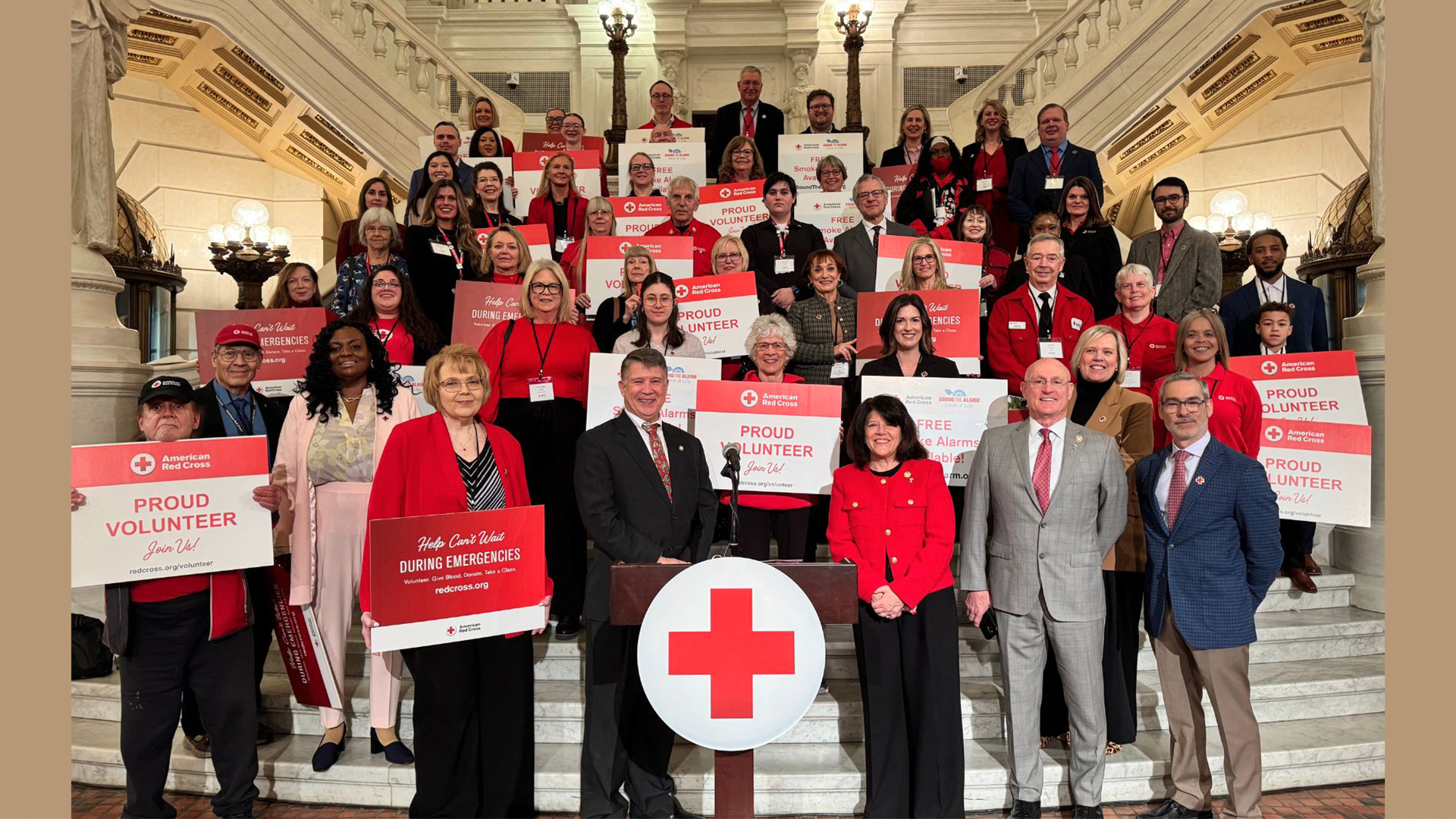 Approximately 30 Red Cross volunteers stand on the Capitol Rotunda steps in Harrisburg.
