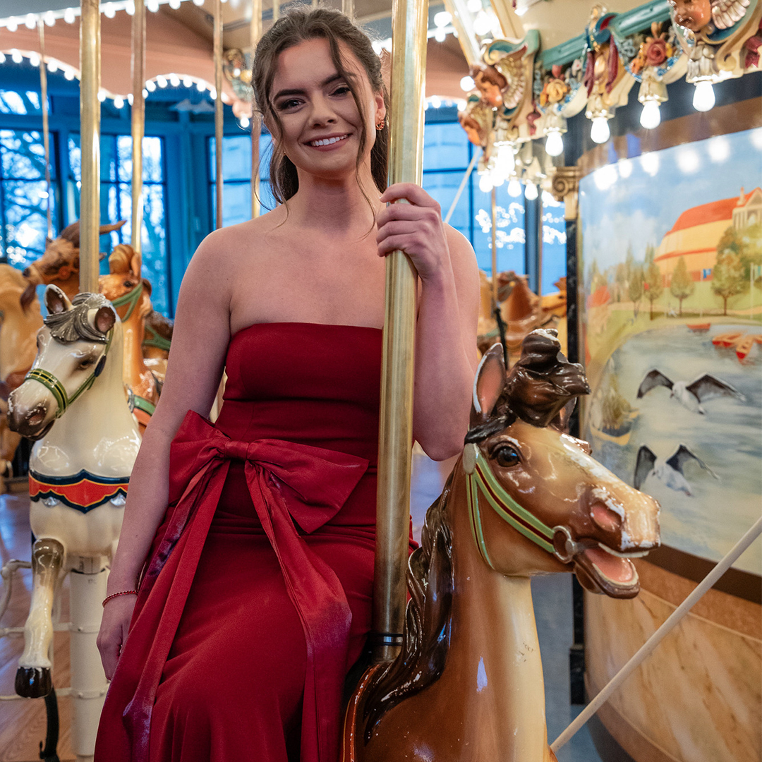 Photo of Emily Gindele riding a horse on the Please Touch Museum carousel