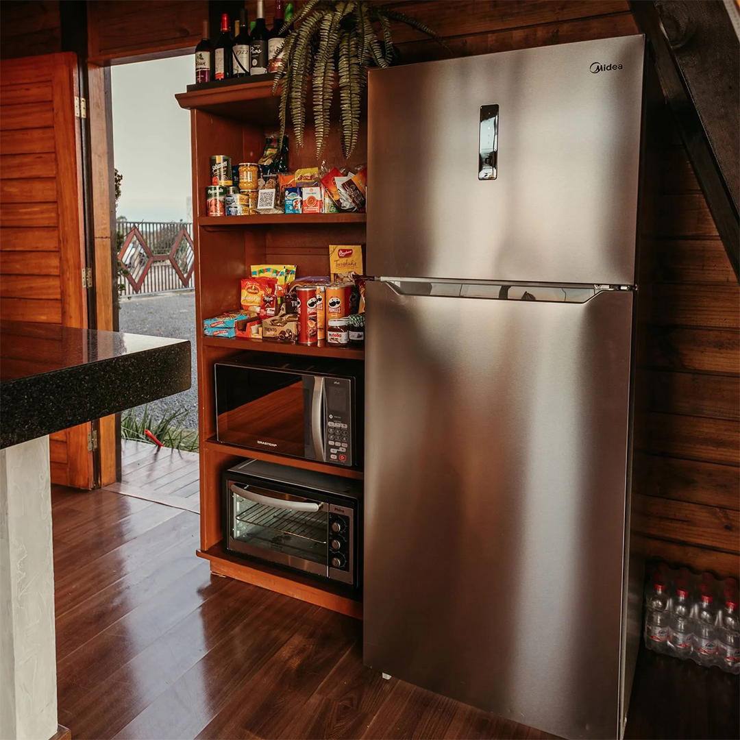 A warm, rustic kitchen featuring a sleek silver fridge and modern appliances.