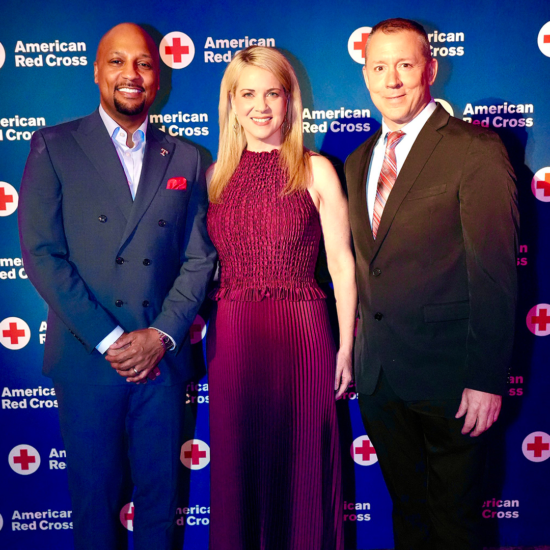 Photo of Danny Pommells, Amy Fadool and Ricky Bottalico standing in front of a Red Cross step-and-repeat
