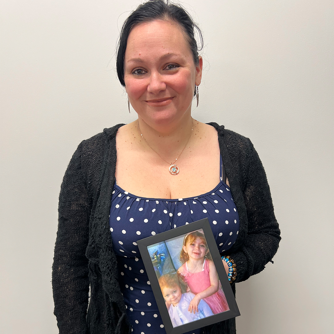 Nora Magras is shown holding a framed picture of her two daughters, Felisha and Hailey, taken at Easter in 2008 shortly before the fire.