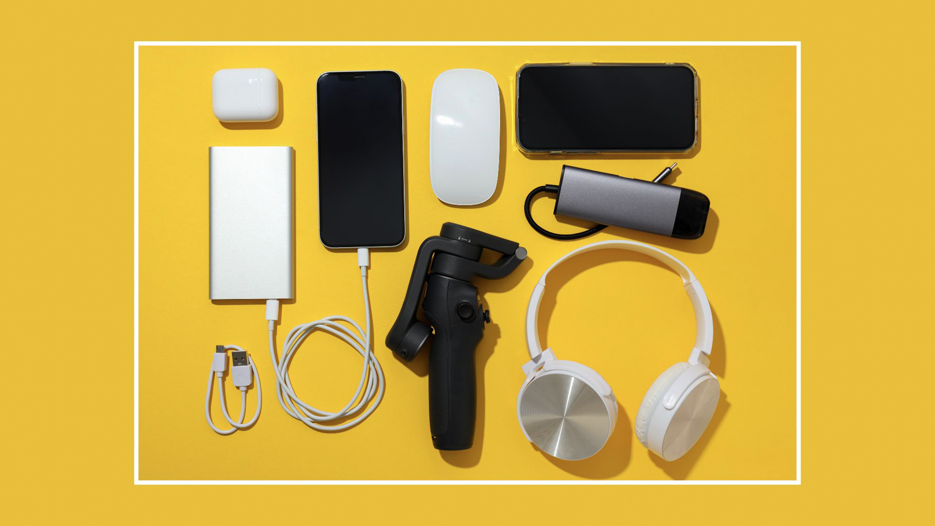 illustration of various common rechargeable electronic devices neatly arranged on a flat surface, including a yellow power bank, smartphones, a power adapter, a charging dock, cables, and headphones.
