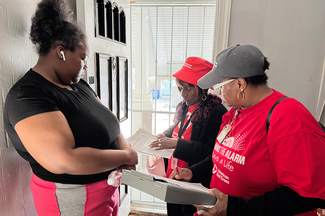Photo of Red Cross volunteers talking with Philadelphia resident about fire safety.